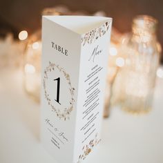 the table numbers are placed on top of each other in front of candles and glass vases