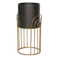 a black and gold metal planter with two handles on the bottom, in front of a white background