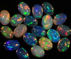 several opal stones are shown on a black surface