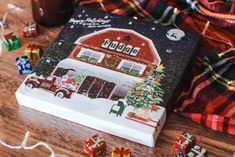 a book with christmas decorations on it sitting on top of a wooden table next to other items