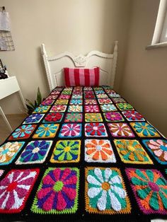 a crocheted bedspread with colorful flowers on it