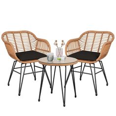 two wicker chairs and a table with a vase on the top, both sitting next to each other