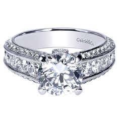 a white gold engagement ring with two rows of diamonds on the band and a round center stone