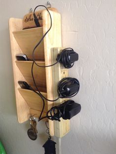 a wooden rack holding several pairs of shoes and headphones on top of a wall