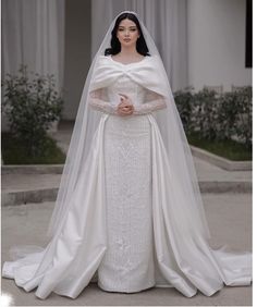 a woman in a white wedding gown and veil