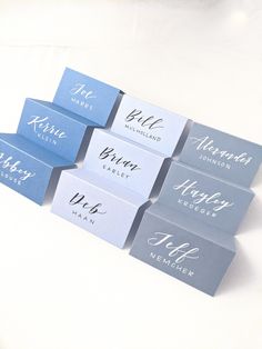 six business cards sitting on top of each other in blue and grey colors with the names of different businesses