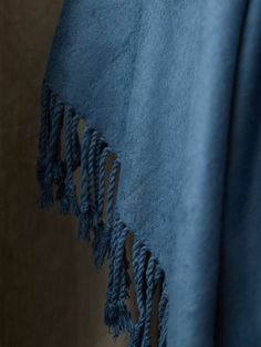 a blue blanket with tassels hanging from it