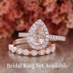 two wedding rings with an oval cut peach sapphire surrounded by smaller round diamond halos