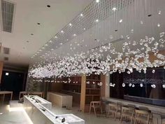 a room filled with lots of white furniture and chandelier hanging from the ceiling