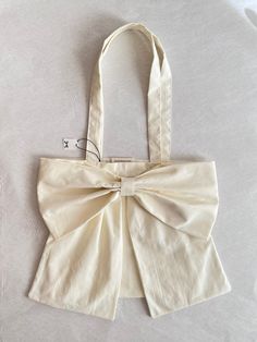 a white bag with a large bow on it