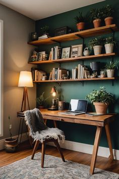 a desk with a laptop on top of it next to a lamp and potted plants