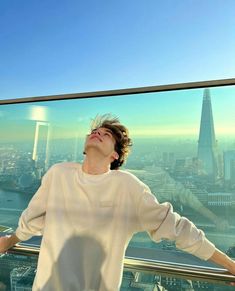 a woman standing in front of a window looking up at the sky