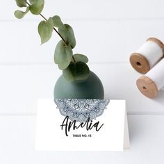 a plant is sitting on top of a table next to some twine spools