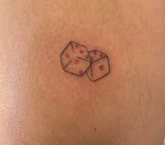 two dice tattoos on the back of a woman's stomach, with hearts in them