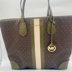 Nwot Mk Mk Signature Logo Eva Large Tote. Authentic Guaranteed - Mk Signature Coated Canvas - Trim: 100% Leather - Printed Center Stripe - Gold-Tone Hardware - Open Top/No Closure - 10.5” Handle Drop - Interior: Back Slip Pocket With Approx. 8" L X 0.5" H Removable Snap Pouch - Color: Brown/Olive - 7 3/4" (L) X 3 1/2" (H) X 3/4" (W) Michael Kors Eva Large Tote, Open Top, Signature Logo, Large Tote, Michael Kors Jet Set, Womens Tote Bags, Top Handle Bag, Michael Kors, Pouch