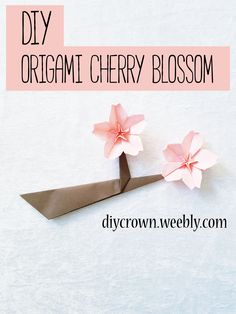 two origami cherry blossoms on a pair of scissors with text overlay that reads diy origami cherry blossom