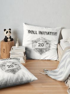 two pillows on the floor next to some books and a stuffed panda bear