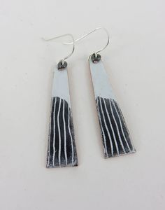 These dangle earrings have a 4cm x 0.8cm copper rectangle coated in enamel, on a silver wire with a silver bead. There is an extra layer of enamel painted on with hand drawn line detail. Fired in the kiln at 830 degrees. Modern White Rectangular Earrings, Nickel-free White Rectangular Jewelry, White Rectangular Metal Jewelry, White Earrings With Black Enamel, Hand Painted Jewelry, Enameled Copper, Art Clay, Enamel Earrings, Silver Bead