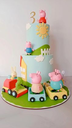 a three tiered cake with pep the pig on top and other animals around it