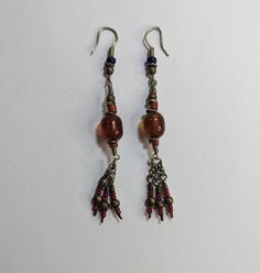 Vintage Handmade Artisan Beaded Earrings Dangle Drop Brown Red Glass Beads Twisted Wire Details 3" Tassel Ends Approximately 3" long Handmade Red Beaded Long Drop Earrings, Handmade Red Long Drop Beaded Earrings, Red Traditional Beads For Crafting, Traditional Red Beads For Crafting, Red Round Bead Earrings For Festivals, Red Czech Glass Beaded Earrings With Dangling Beads, Traditional Red Beaded Earrings With Colorful Beads, Traditional Dangling Beads For Crafting, Adjustable Red Czech Glass Beaded Earrings