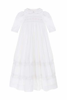 A future family heirloom, this traditional Christening or ceremony gown is the most exquisite gown in the Annafie catalogue yet! Truly fit for a little princess or prince, it features delicate hand smocking and embroidery both across the chest and on the skirt. The ruffled peter pan collar and elegant sleeves create a romantic silhouette which is completed by the traditional long skirt that will drape over your arms as you carry your baby. Made from 100% fine, breathable and extremely luxurious Elegant Fitted Smocked Dress With Lace Trim, Wedding Dress With Smocked Bodice And Empire Waist, Elegant Smocked Dress With Smocked Cuffs For Baptism, Elegant Cotton Smocked Dress, Elegant White Smocked Dress With Lace Trim, Elegant Smocked Ruffle Dress For Baptism, Elegant Wedding Dress With Smocked Bodice, Elegant Baptism Dress With Smocked Bodice, Elegant White Prairie Dress With Fitted Bodice