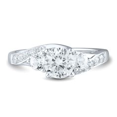 a three stone diamond ring with two side stones on the band and an oval shaped center stone