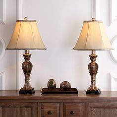 two lamps sitting on top of a wooden table