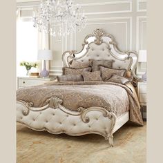 a bedroom with a bed, chandelier and two lamps on the nightstands