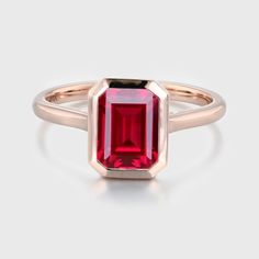 a pink tourmaline stone in a rose gold ring on a white background,