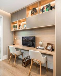 a home office with built - in shelving units and chairs, along with a flat screen tv