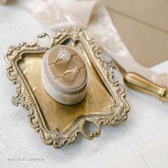 a ring box sitting on top of a gold tray