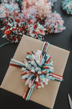 a gift wrapped in brown paper with red, white and blue streamers on it