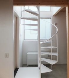 a white spiral staircase in an empty room