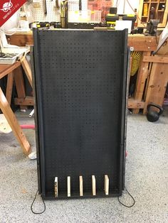 there is a large black board with pegs on it