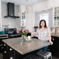 a woman standing in a kitchen next to an island