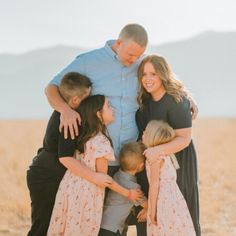 a family hugging each other in the middle of a field