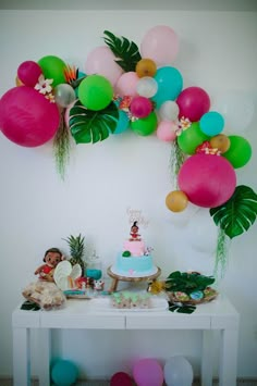 a table with balloons and cake on it