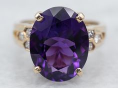 This exquisite yellow-gold cocktail ring features a central amethyst stone surrounded by dazzling diamond accents. Crafted with the finest materials, this remarkable piece is sure to impress for any special occasion.Metal: 18K Yellow GoldGem: Amethyst 5.68 CaratsGem Measurements: 11.0 x 14.1 mm, OvalAccents: 6 Diamonds totaling .12 Carats, SI in Clarity, G-H in ColorRing Size: 6.75Marks: "750" Stamped on the inside band Amethyst Cocktail Ring, Yellow Gold Cocktail Ring, Amethyst Stone, Cocktail Rings, Amethyst, Yellow Gold, Band, Stone, Gold