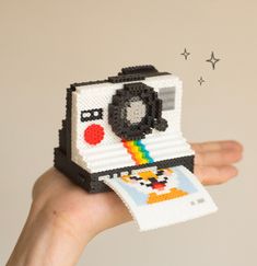 a hand holding up a small toy camera