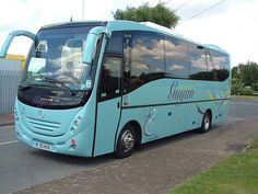 a blue bus is parked on the side of the road