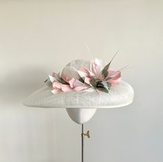 "A stunningly beautiful ivory and blush feather headpiece, perfect for Royal Ascot or the Mother of the Bride.  Made from ivory sinamay straw, this elegant headpiece features trimmed coque feathers in shades of pale rose pink, ivory and pale green that twist half way round the crown. Sitting to the side is a flower constructed from pointed feathers in the same shades of pink, ivory and green, with a centre stamen of cream seed beads.  This sweeping brim hat measures 44cm side to side, and 35cm b Pink Feather Trim Fascinator For Wedding, Pink Feather Trim Wedding Hat, Pink Feather Trim Wedding Headpiece, Pink Wedding Costume Hat With Feather Trim, Elegant Pink Feather Trim Costume Hat, Elegant Pink Hat With Feather Trim, Elegant Pink Costume Hat With Feather Trim, Feathered Hats For Kentucky Derby Wedding, Kentucky Derby Wedding Hat With Feathers