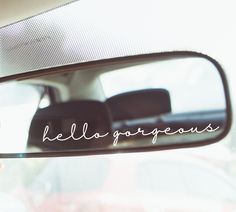 the reflection of a person in a car's rear view mirror that says, hello gorgeous