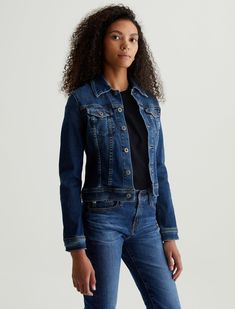 The Robyn Jacket is a slim jean jacket for women featuring a true vintage dark wash with placement shadows, fitted silhouette throughout, and classic chest pockets with tonal button closures. This women’s jacket is designed in a body-hugging 10 oz. Rouge Advanced Stretch Denim—a lightweight, super stretch fabric that lends itself beautifully to light and dark indigo shades.   Rouge Advanced Stretch Denim, 10 Oz. 98% Cotton 2% Spandex Selvage Denim, Knit Loungewear, Sleeveless Wrap Dress, Ag Jeans, Skirt Jumpsuit, Dark Indigo, Jacket For Women, Kids Outerwear, Fitted Silhouette