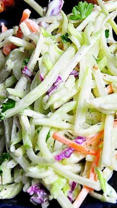 a salad with carrots, celery and onions on a blue plate next to some broccoli