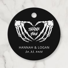 a black and white wedding ornament with two hands in the shape of a heart