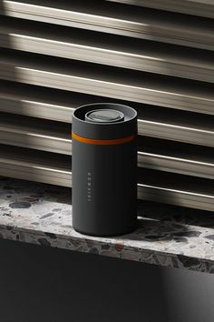 a black and orange can sitting on top of a counter next to a window sill