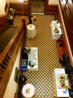 an overhead view of people sitting at tables in a room with yellow and brown flooring