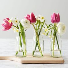 three vases with flowers in them sitting on a wooden board that says araanojosforais