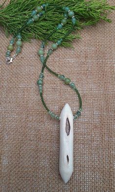 Curious chunky willow wood talismanic necklace.  Heavily scarred  to one side, smooth white willow wood to the other. On a necklace chain of 8 mottled green jade, 6mm prehnite beads and pale green crystal. Solace, or perhaps consolation, comfort, given when times are hard, when you are distraught or disappointed by someone or something, when you are in need of support in your misery. Which is exactly what willow does. She does not take your pain or grief away, but she does support you through it Nature-inspired Green Jewelry With Wooden Beads, White Wooden Beads Necklace For Healing, Green Spiritual Necklace With Wooden Beads, Spiritual Green Necklace With Wooden Beads, Willow Wood, White Willow, Green Crystal, Green Jade, Green Crystals