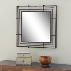 a wooden bowl sitting on top of a dresser next to a wall mounted mirror above it